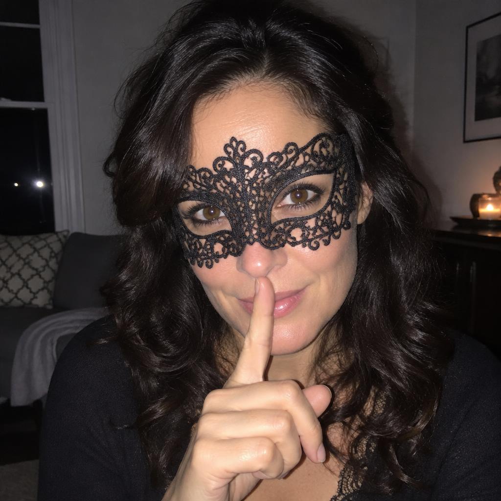 Portrait d’une femme brune aux cheveux ondulés portant un masque de dentelle noire et faisant un geste de silence